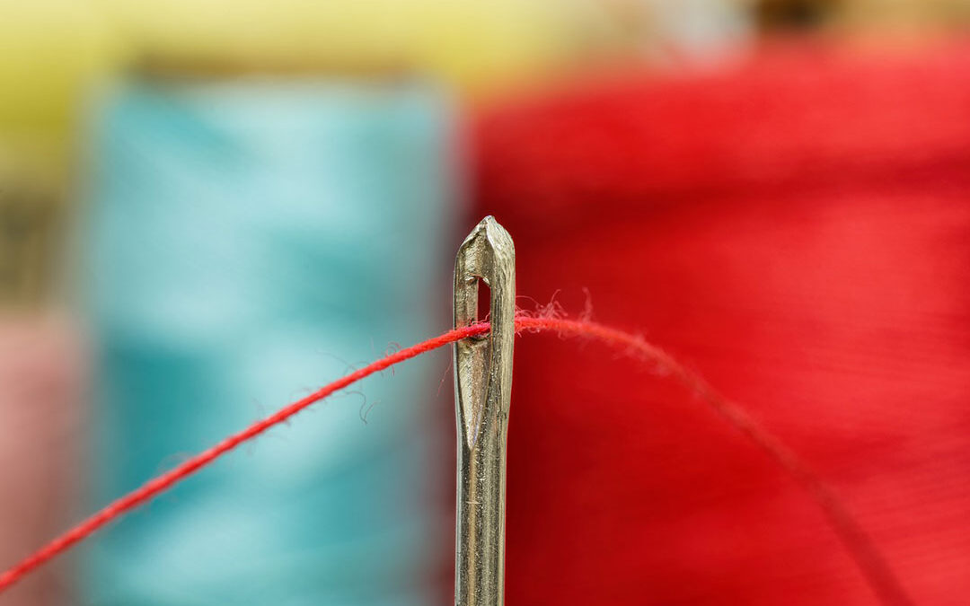 Needle with orange/reddish thread